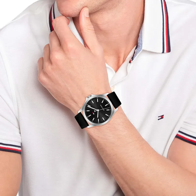 Reloj Tommy Hilfiger con malla de cuero negra en la muñeca de un hombre